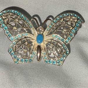 Silver filigree butterfly brooch has vibrant  turquoise color stones